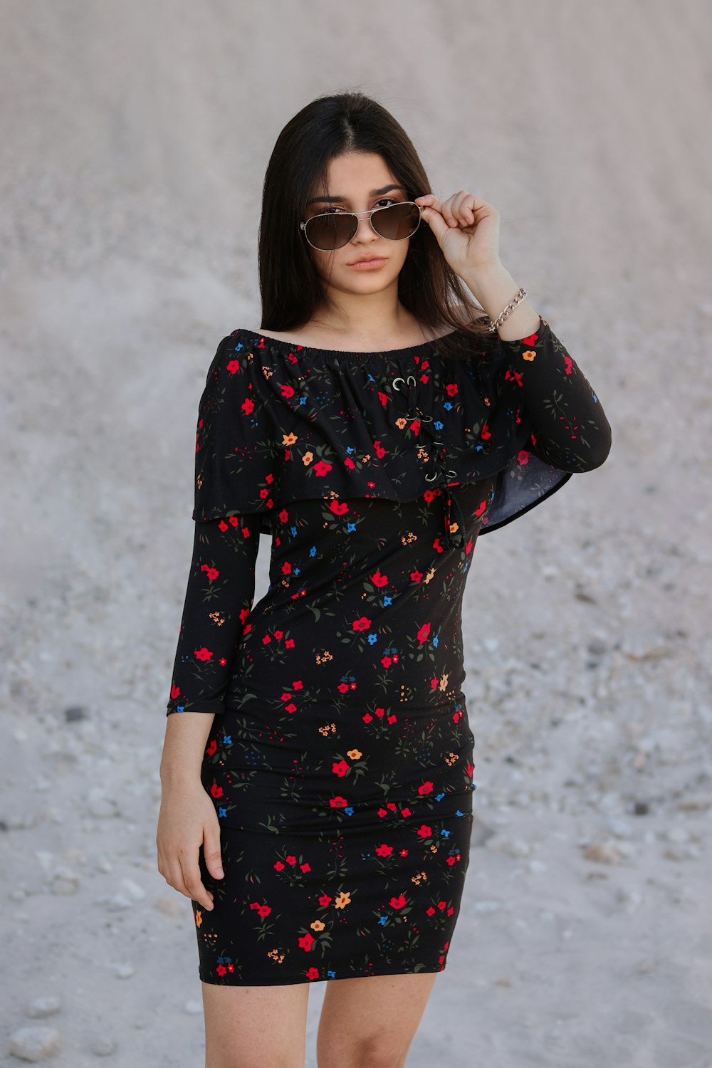 a woman in a black dress and sunglasses