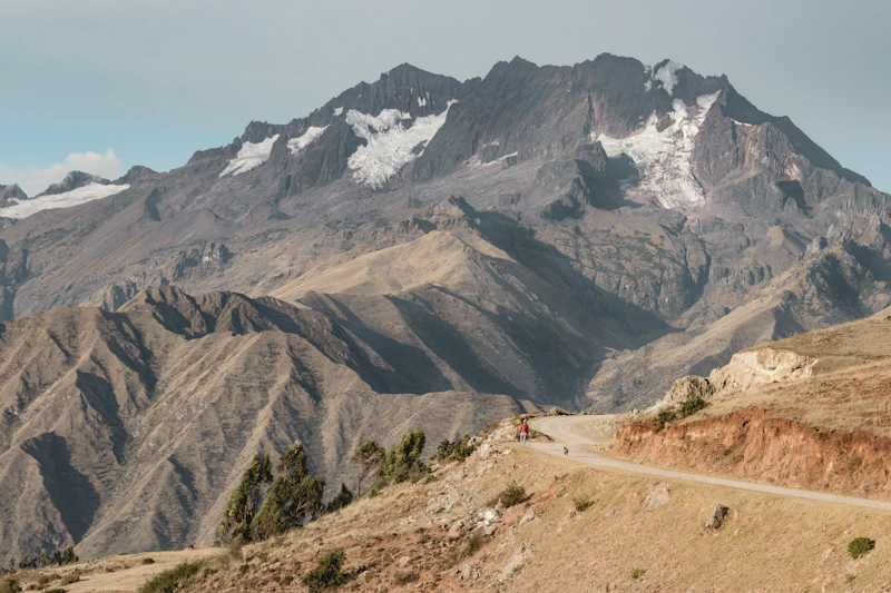 A mountain road winding through the green Sacred Valley below the Chicón peak near Cusco