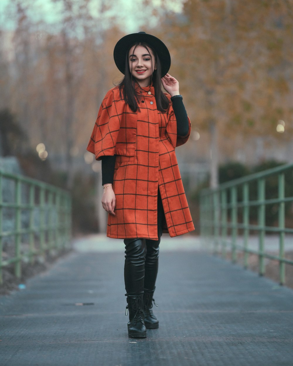 a woman in an orange plaid coat and black boots