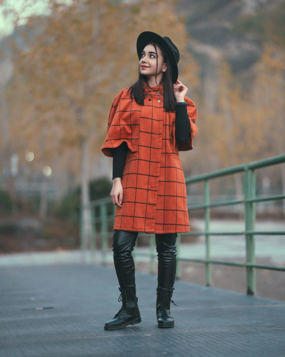 a woman in an orange dress and black boots