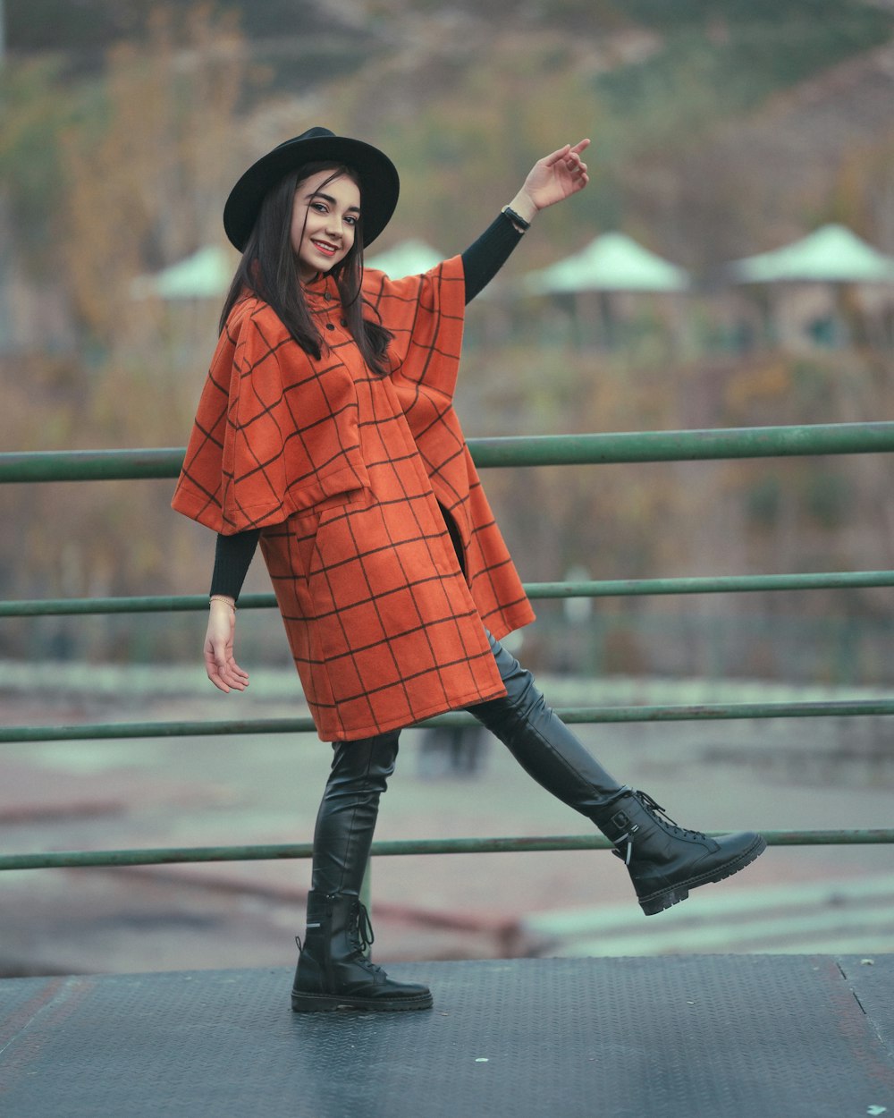 a woman in an orange coat and black boots