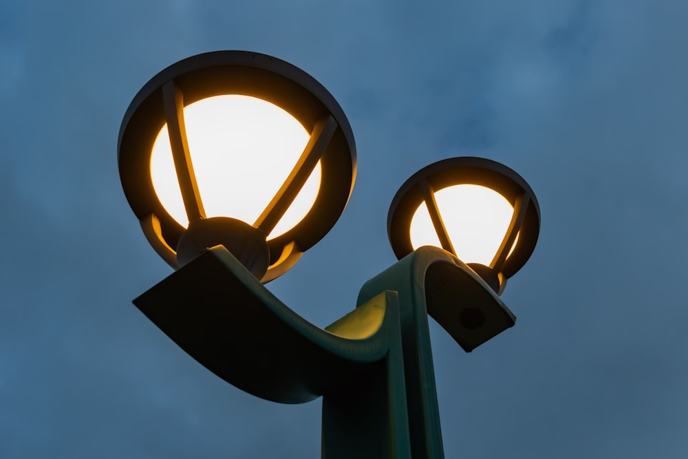 a close up of a street light with a cloudy sky in the background