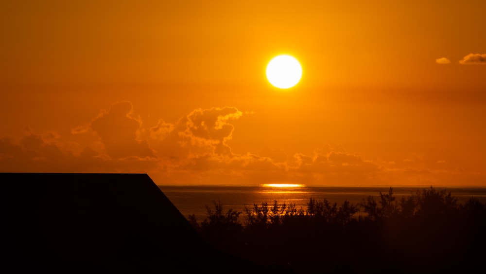 the sun is setting over the horizon of the ocean