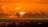 the sun is setting over the ocean with clouds