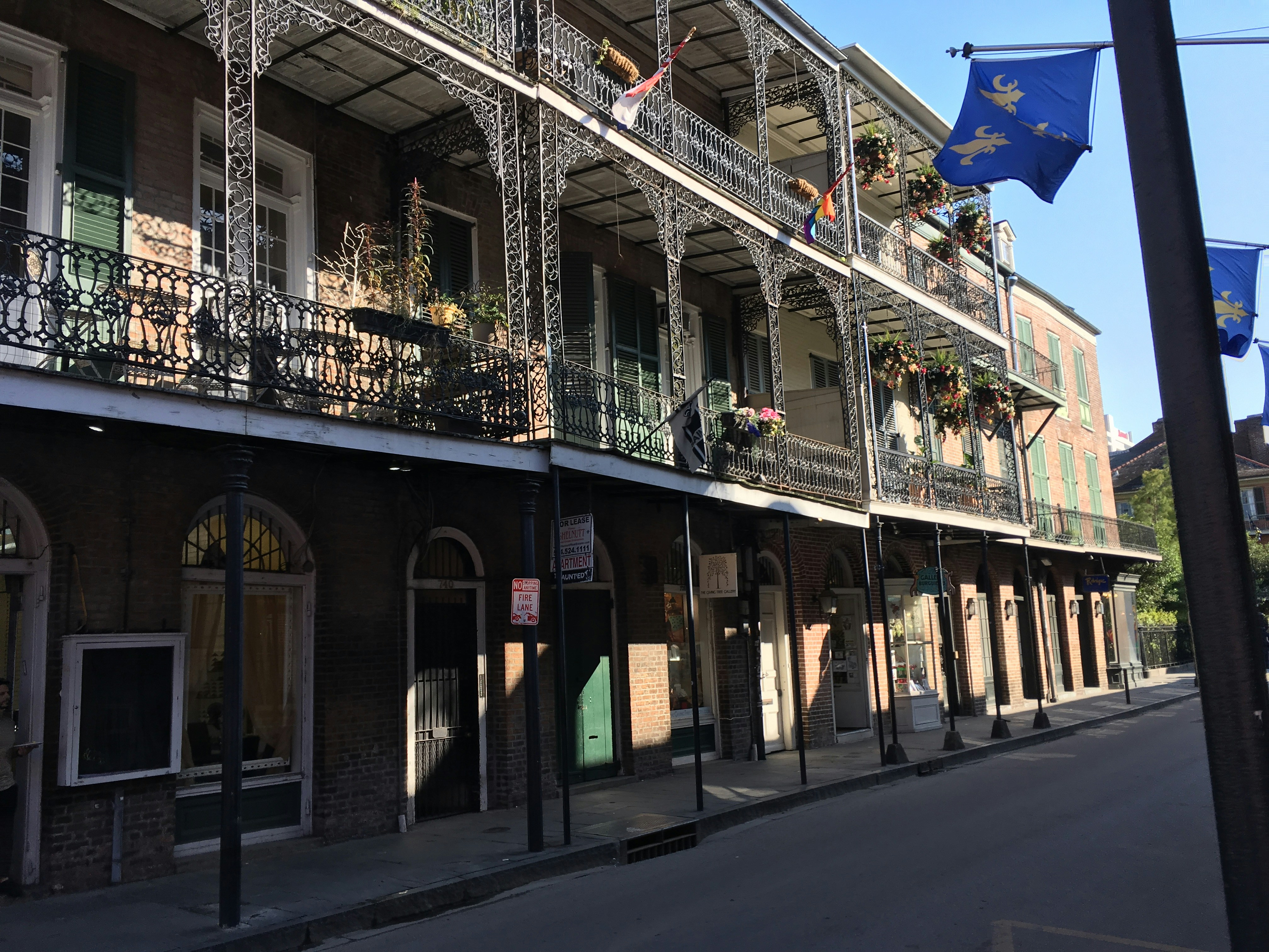 a row of buildings with balconies and wrought iron balconies, Bourbon Street