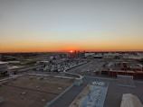 A panoramic view of a sprawling industrial township under development during sunset.