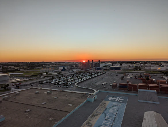 A panoramic view of an industrial site at sunset with workers conducting safety inspections.
