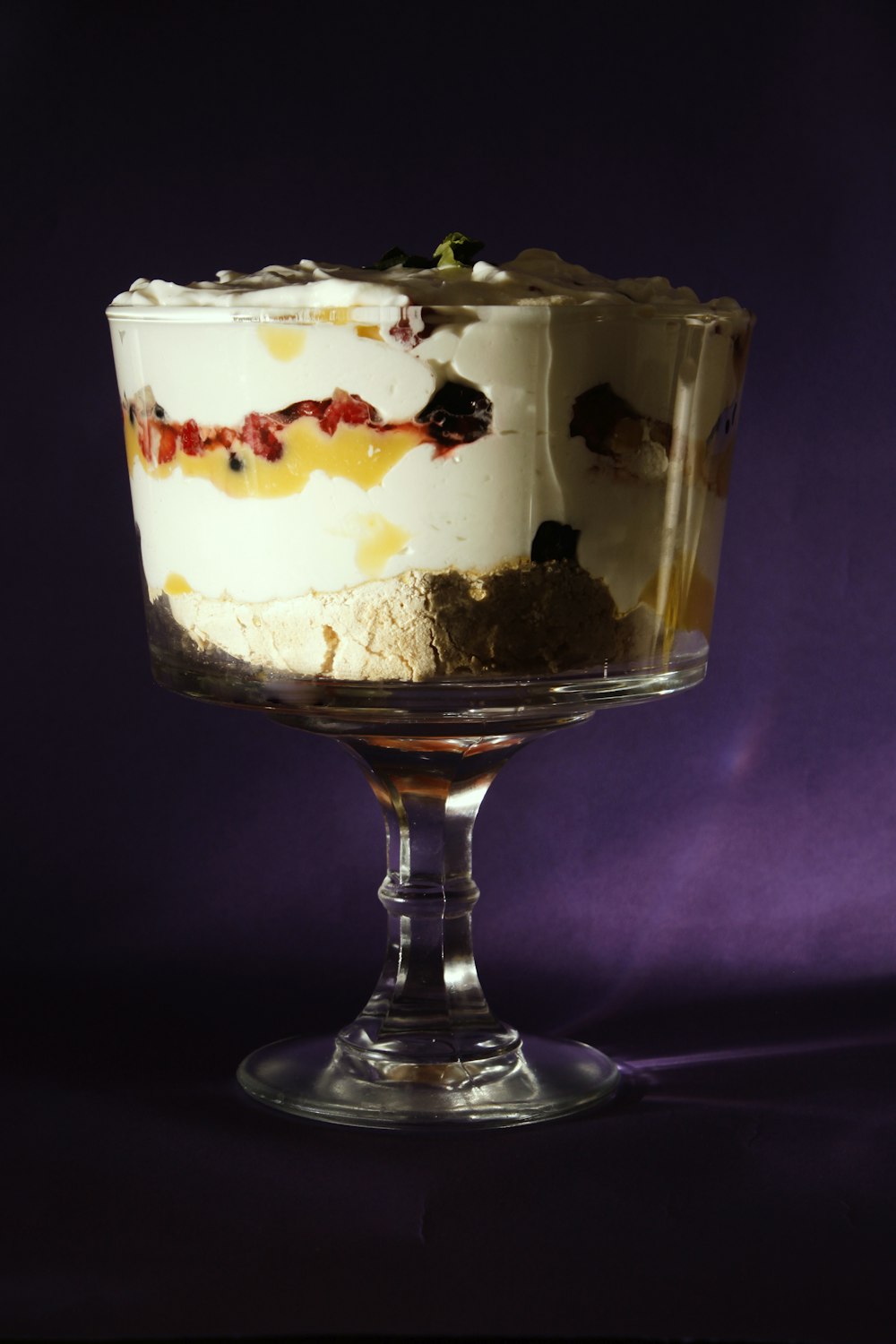 a dessert in a glass dish on a purple background