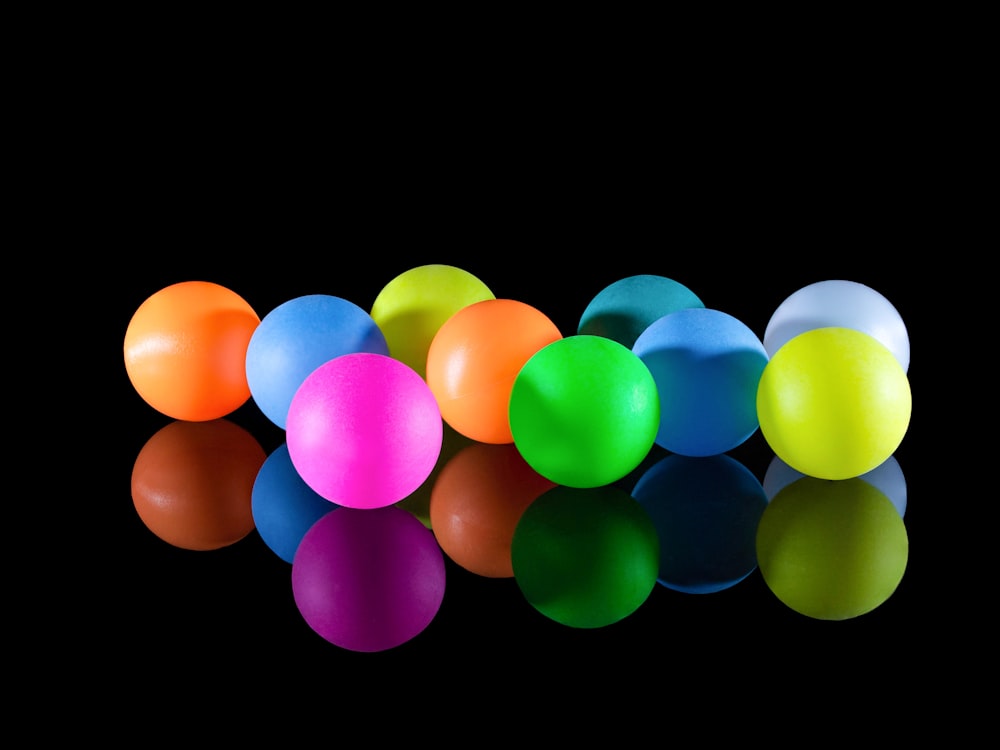 um grupo de bolas de plástico sentadas em cima de uma superfície preta