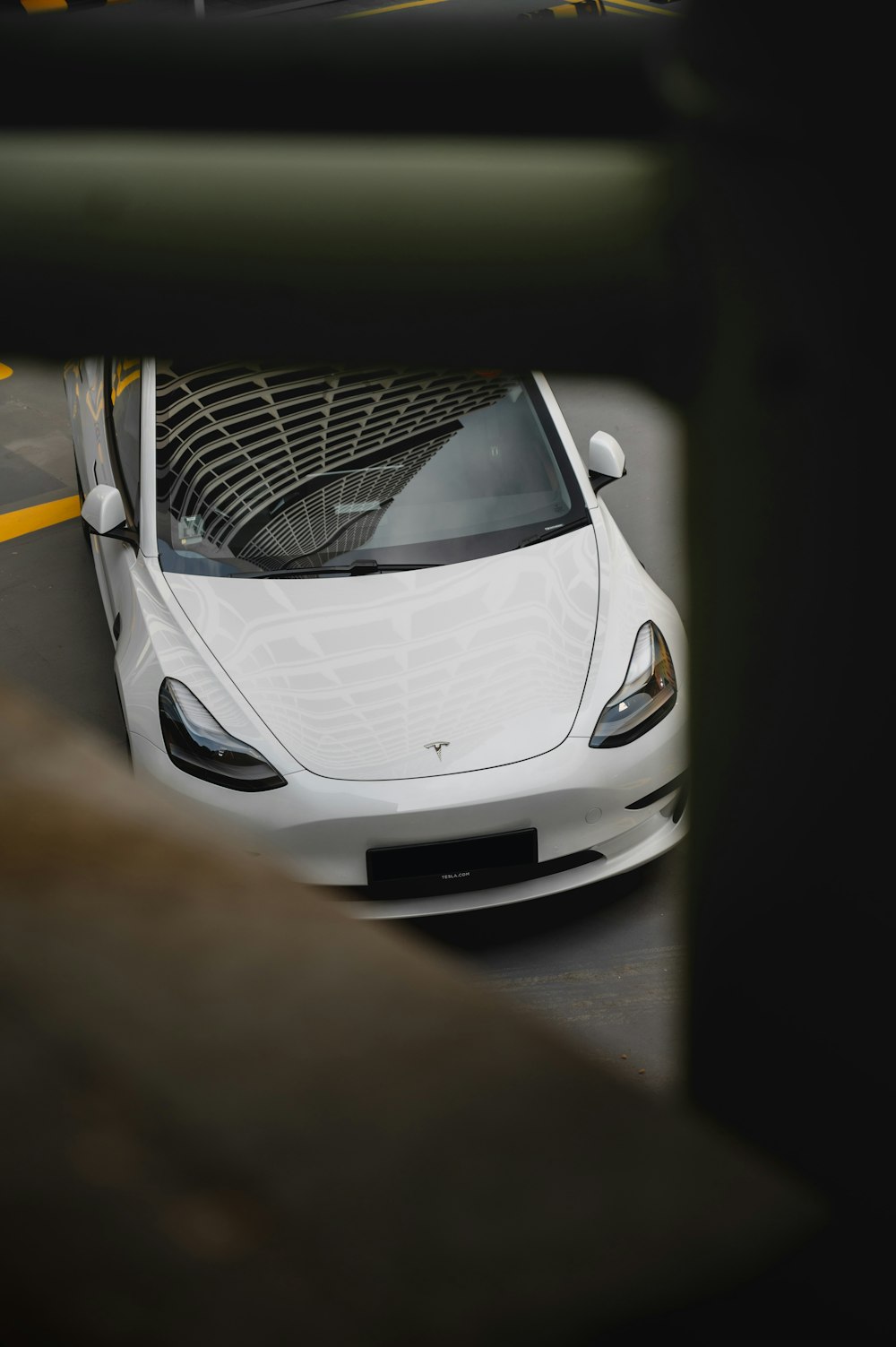 a white car driving down a street next to a tall building