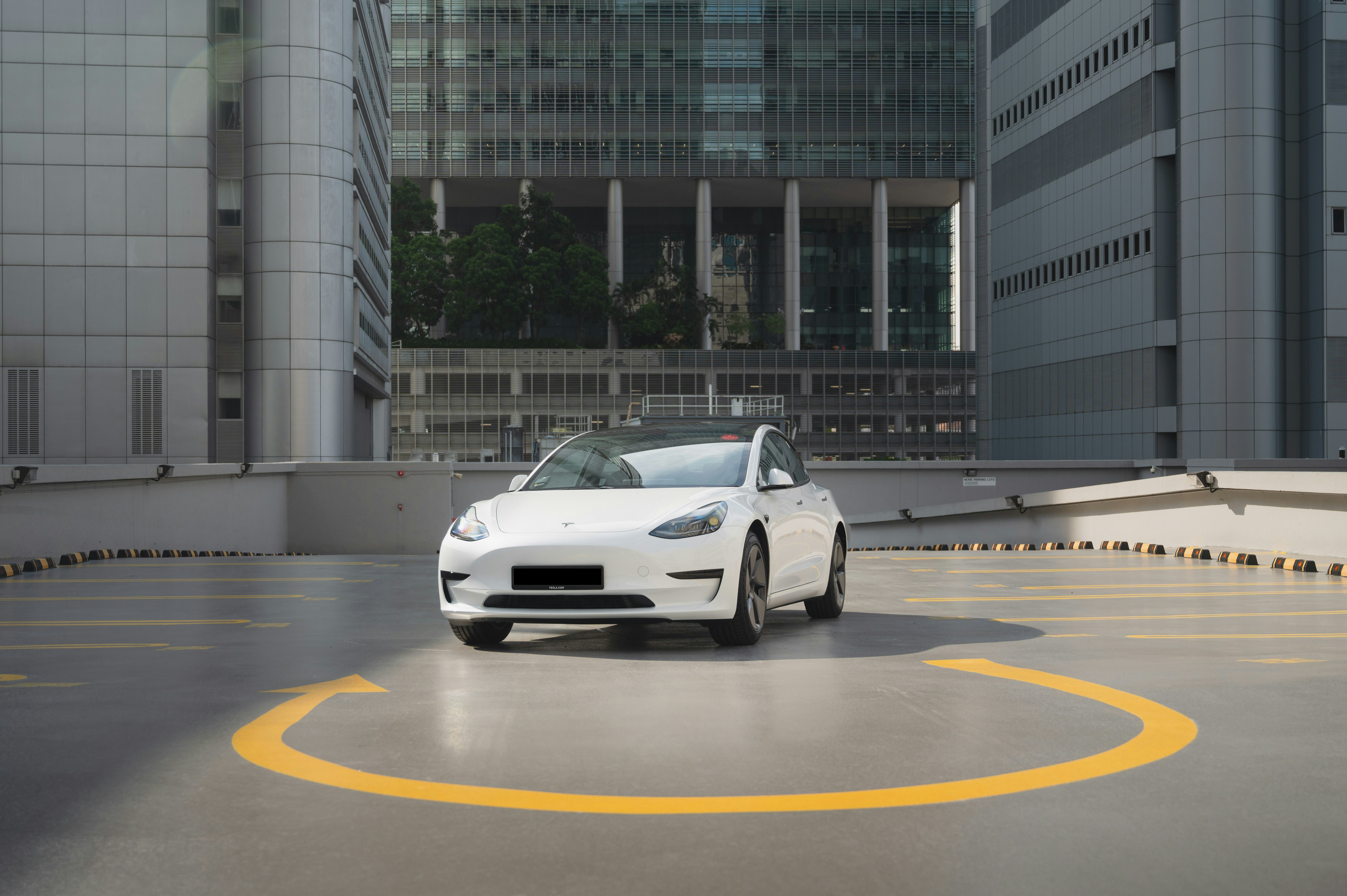 a white car is parked in a parking lot