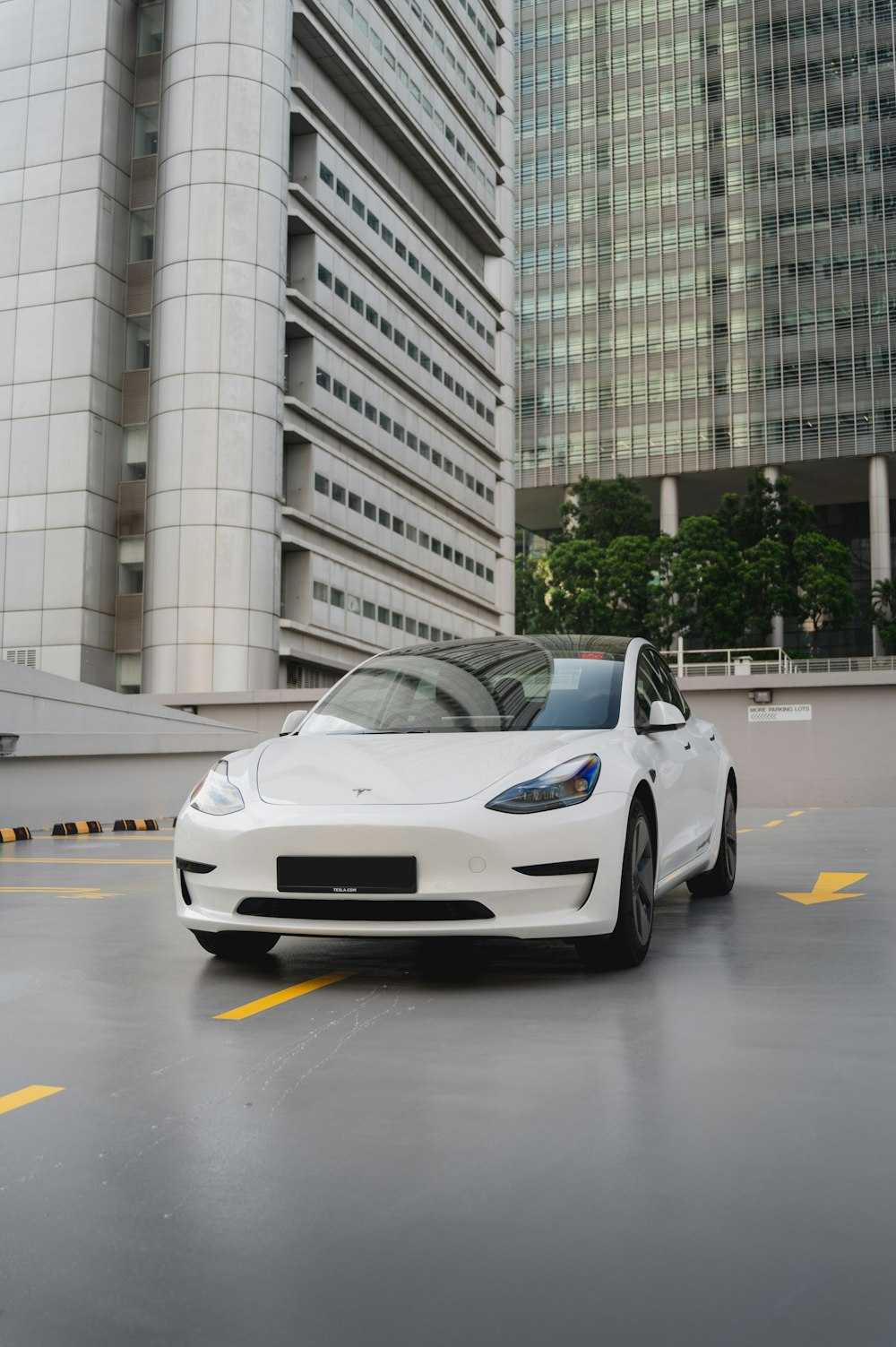 a white car parked in front of a tall building