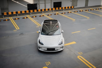 a white tesla model 3 in a parking lot