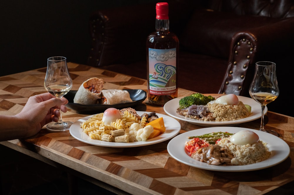 a table with plates of food and a bottle of wine