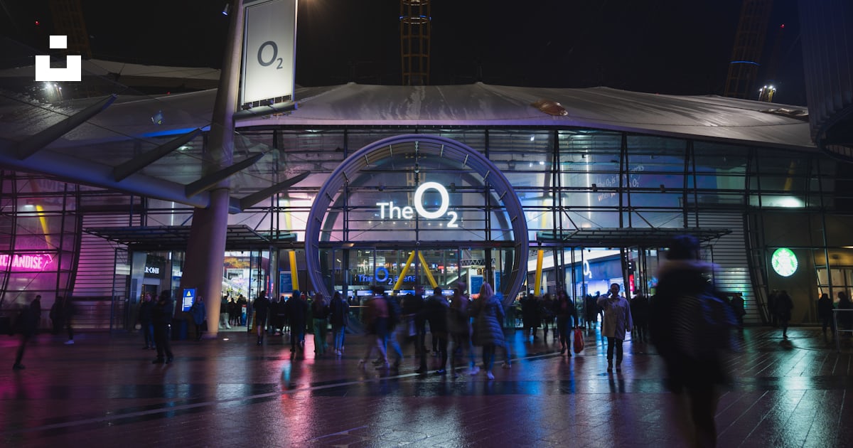 A group of people standing outside of a building at night photo – Free ...