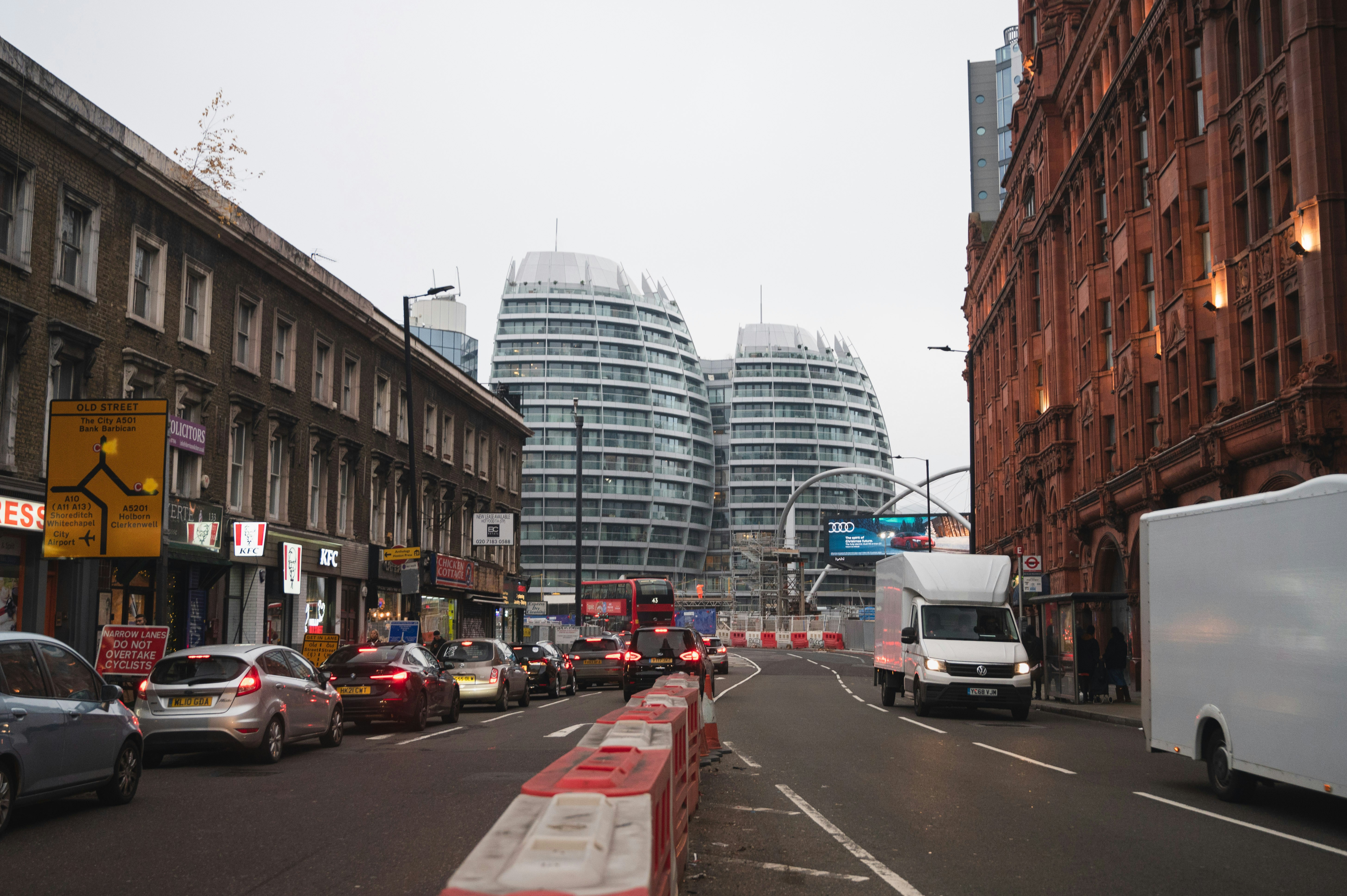 a city street filled with traffic next to tall buildings