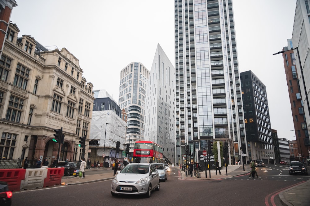 a white car driving down a street next to tall buildings