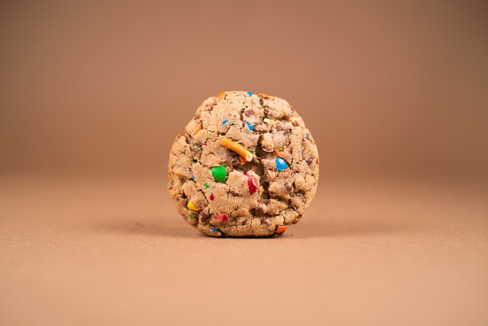 a cookie with sprinkles on a brown background