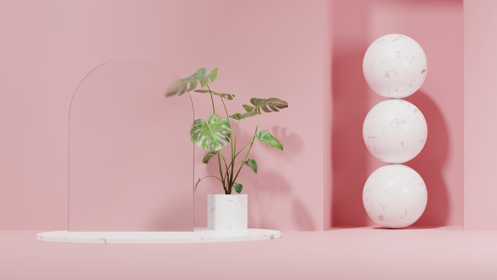 Una habitación rosa con una planta en un jarrón blanco