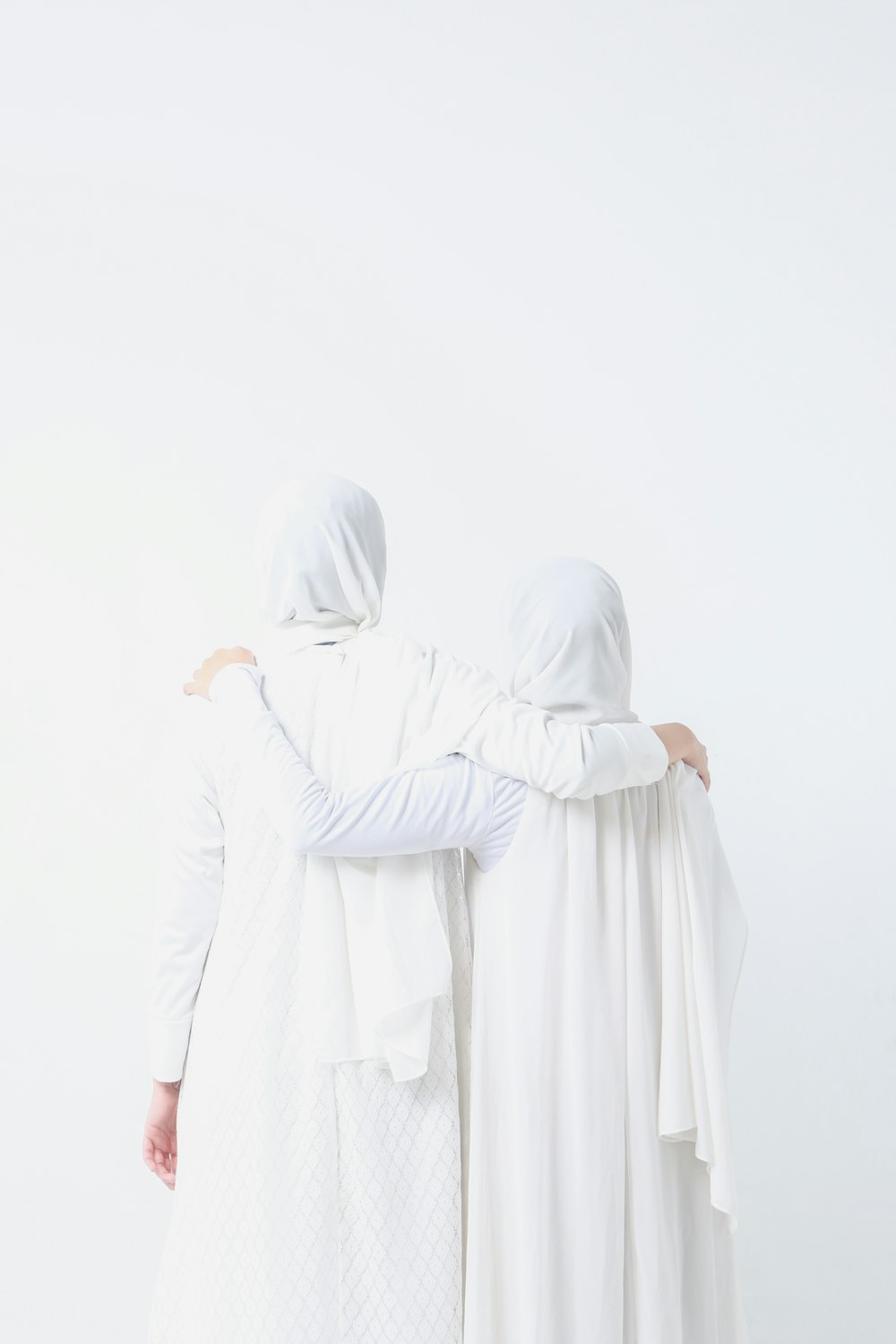 two women dressed in white standing next to each other
