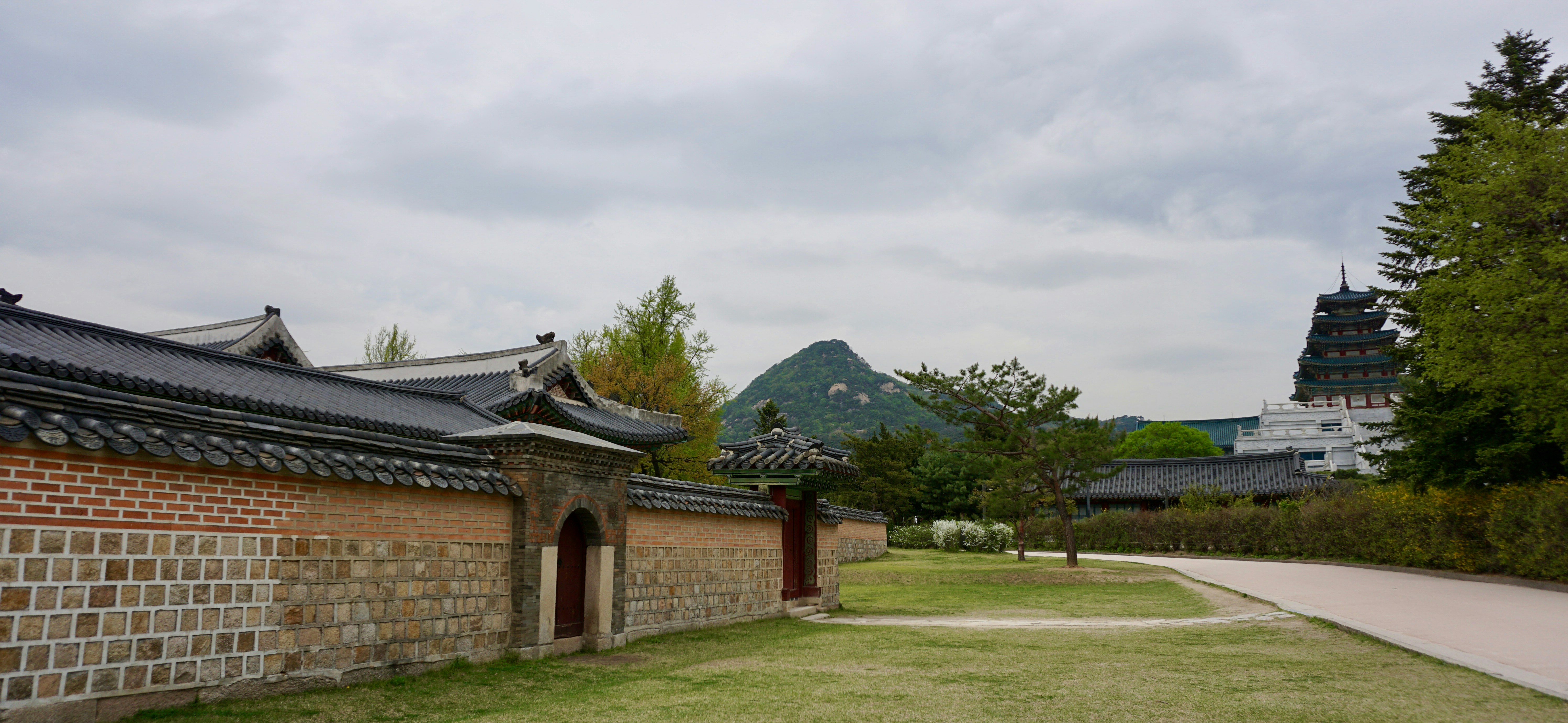 a stone wall with a building in the background
