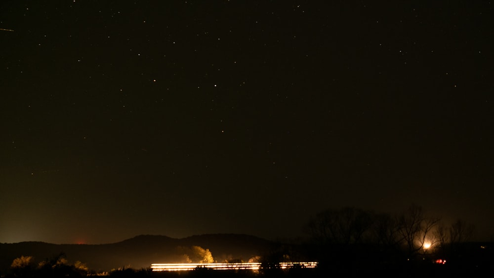 a night sky with stars and a train on the tracks