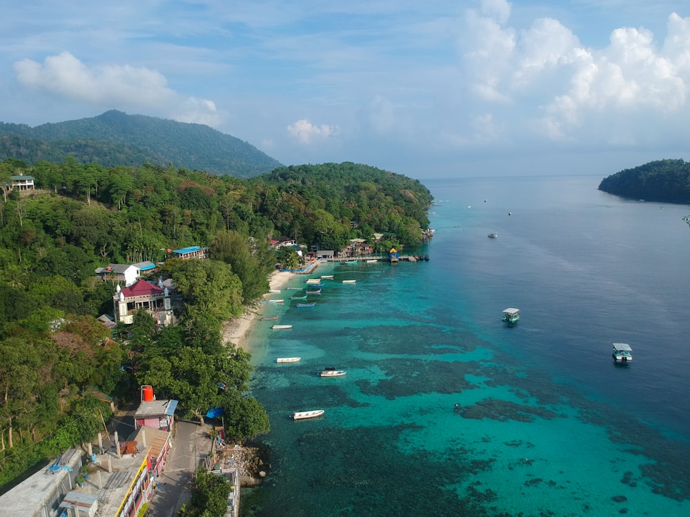 an aerial view of a beach with boats in the water