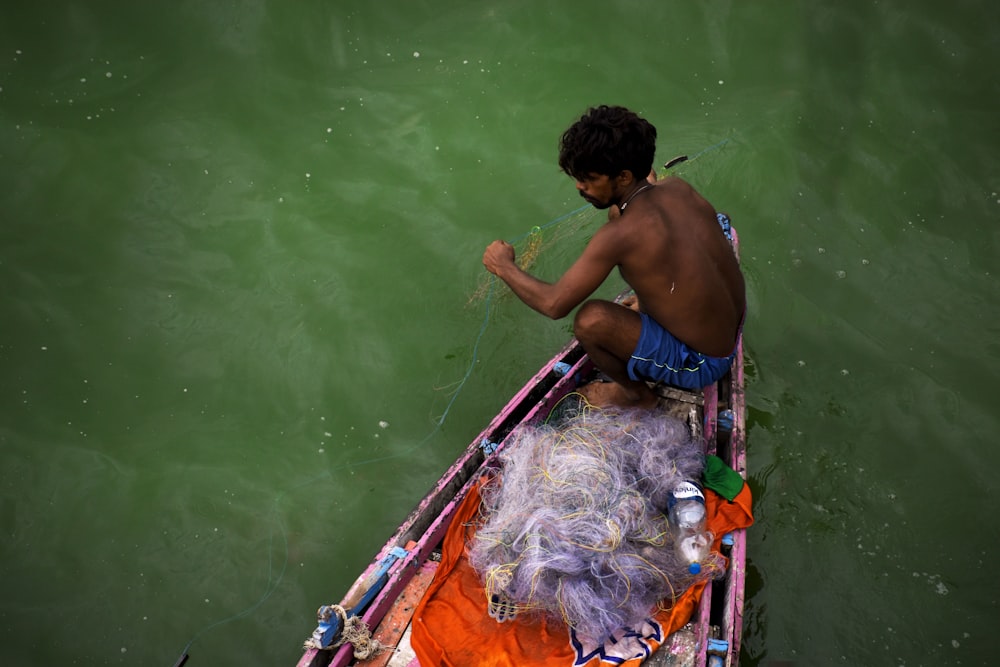 a man sitting in a boat on a body of water