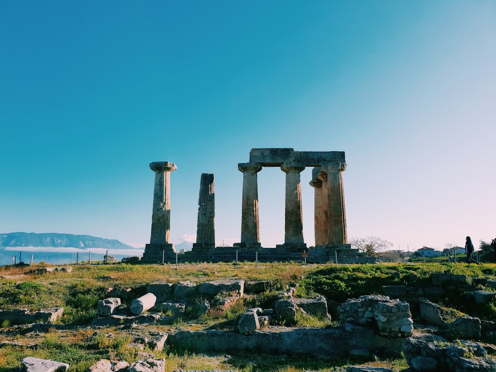 a group of stone pillars sitting on top of a lush green field