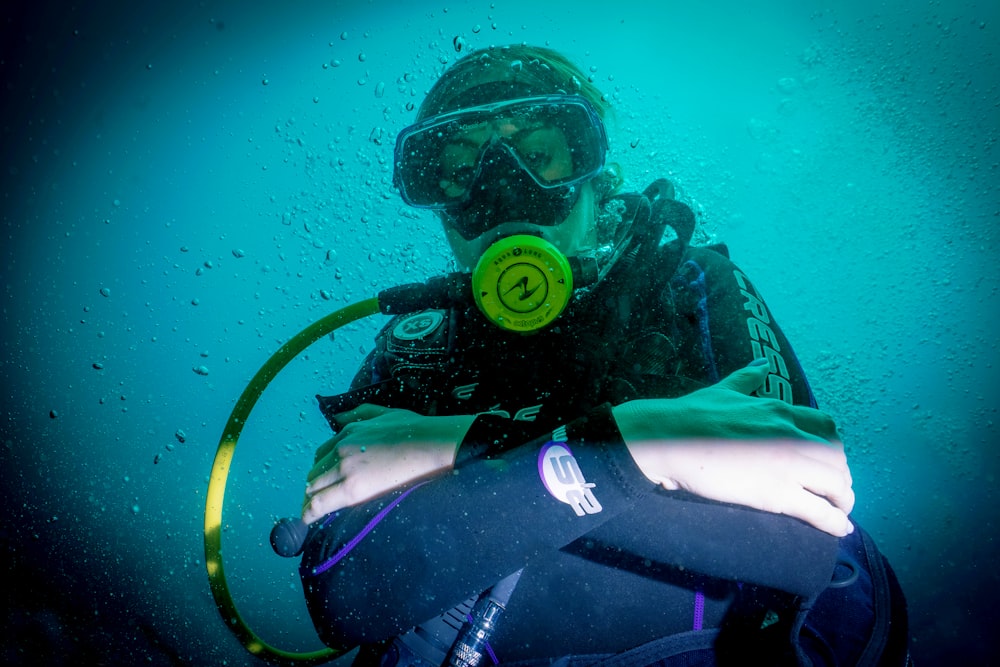 a person wearing a scuba suit and a mask in the water