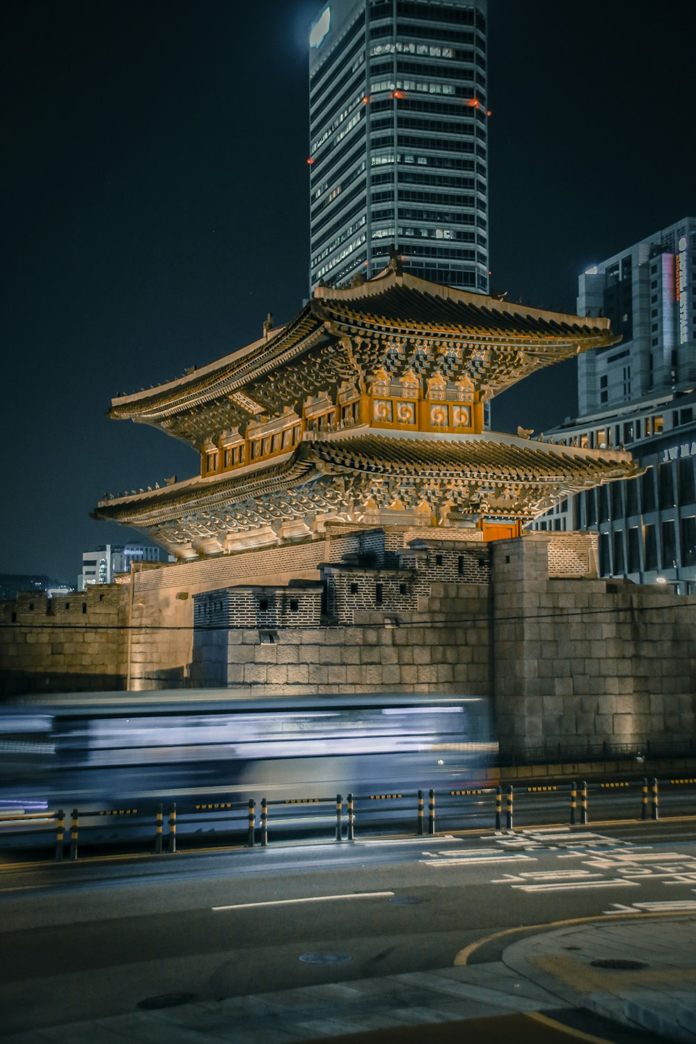 a train passing by a tall building at night