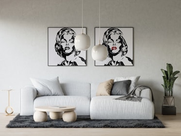 a living room with a white couch and two paintings on the wall