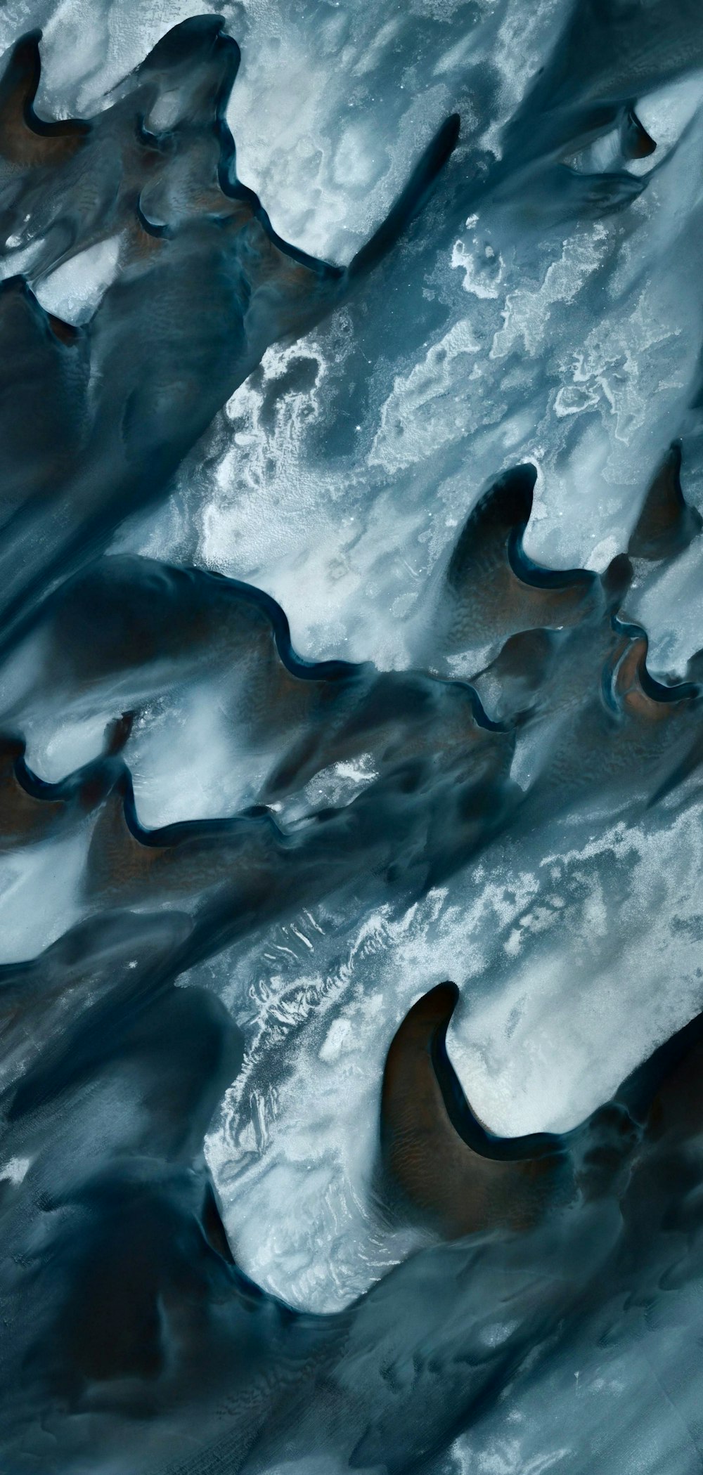 an aerial view of water and ice in the ocean