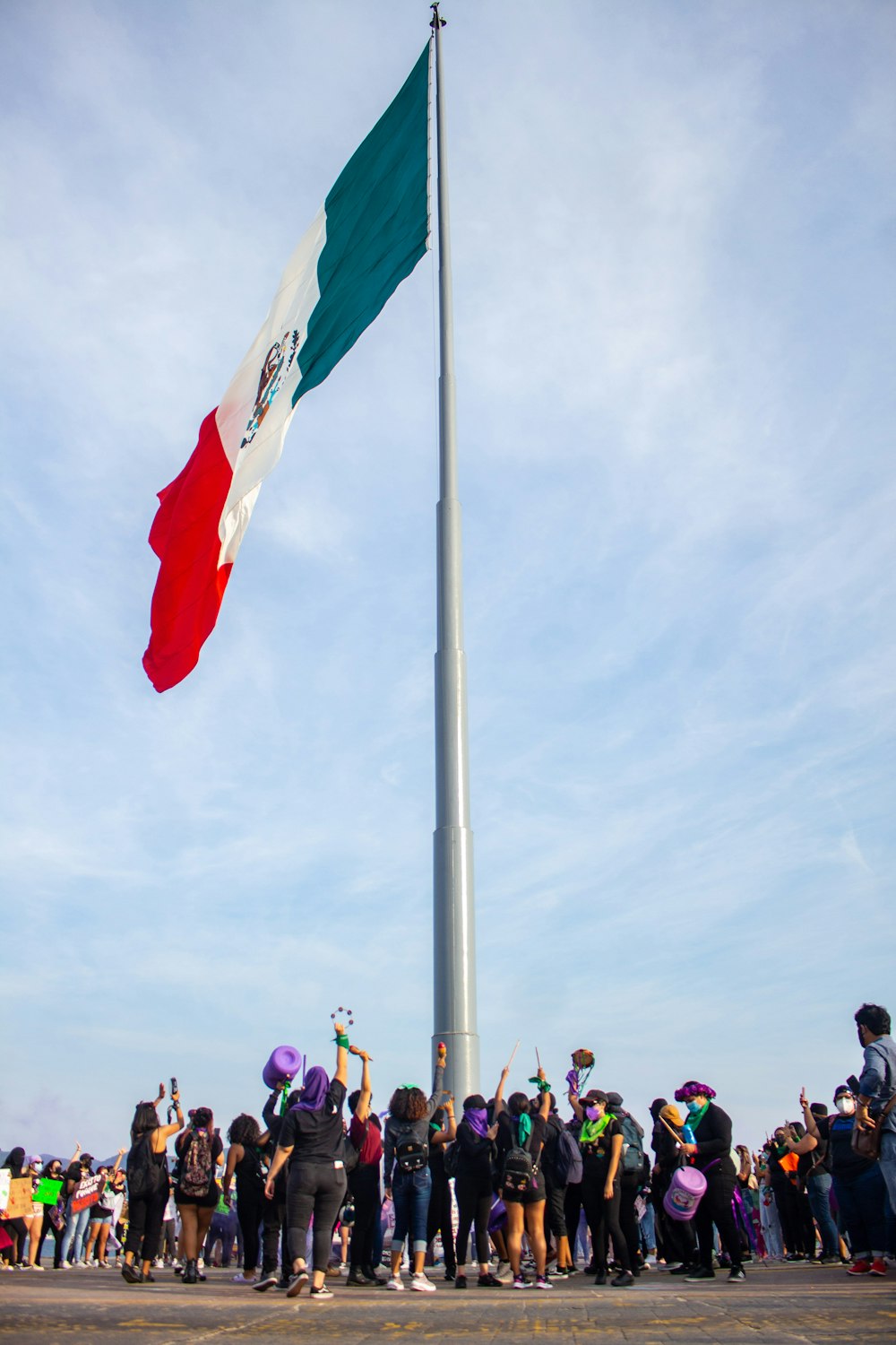 a group of people standing around a flag pole