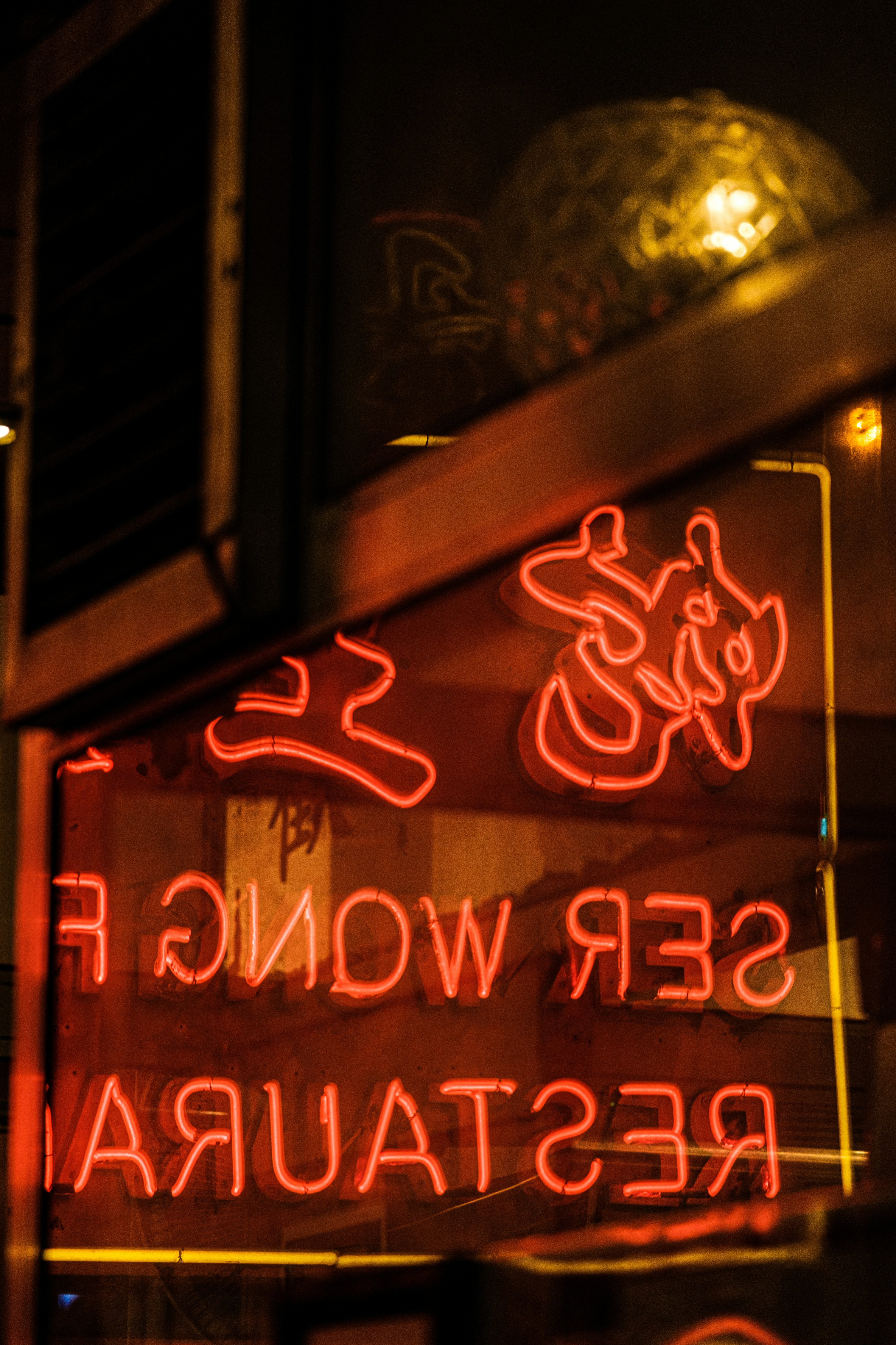 a neon sign that says serrwong fish restaurant