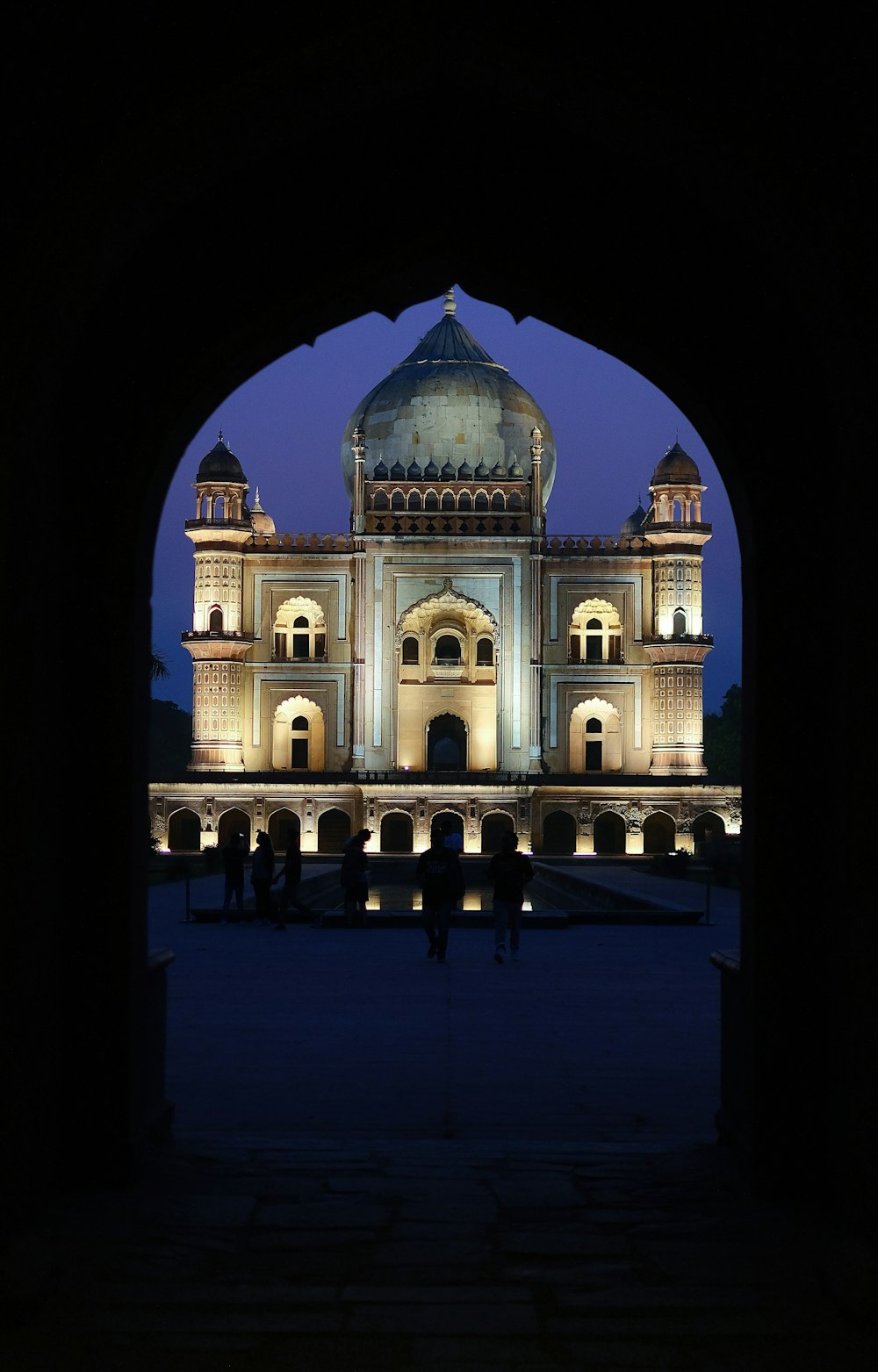 a view of a building through an archway at night