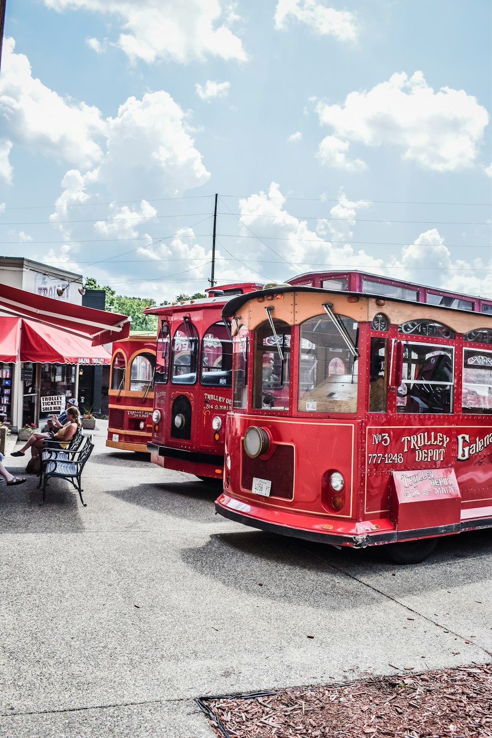 a group of red trolleys parked next to each other