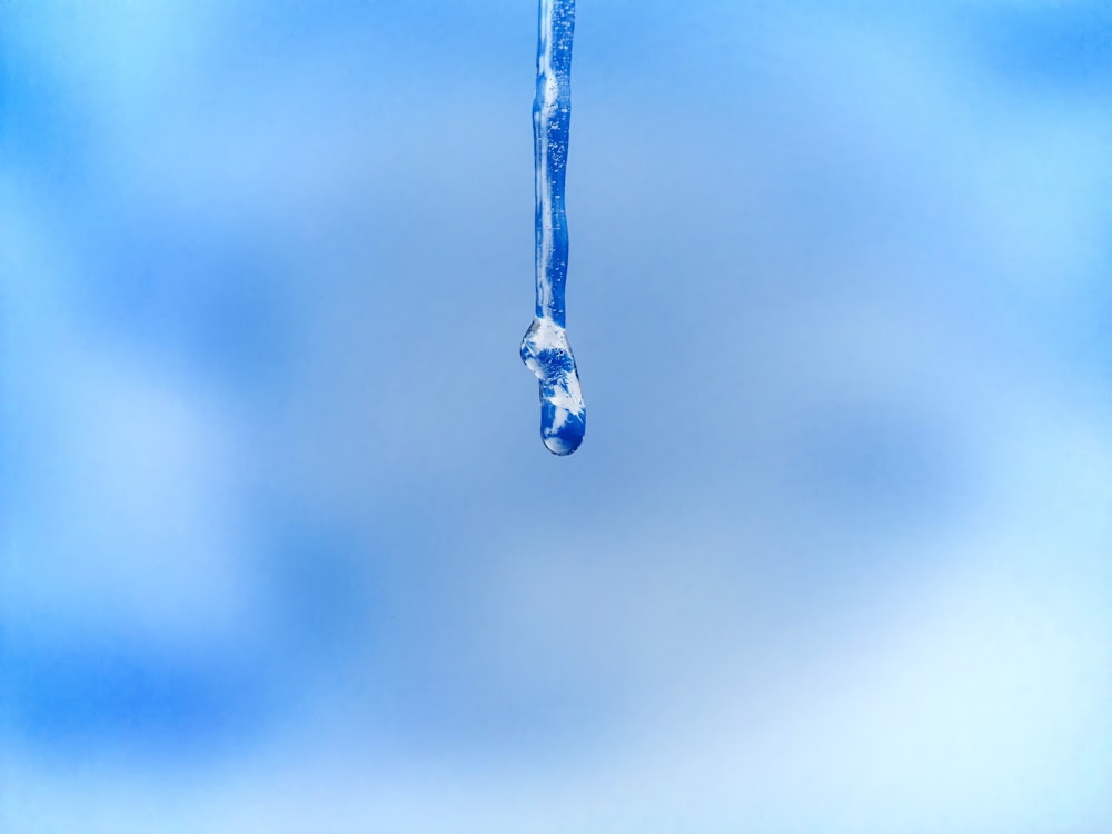 a drop of water that is hanging from a pipe