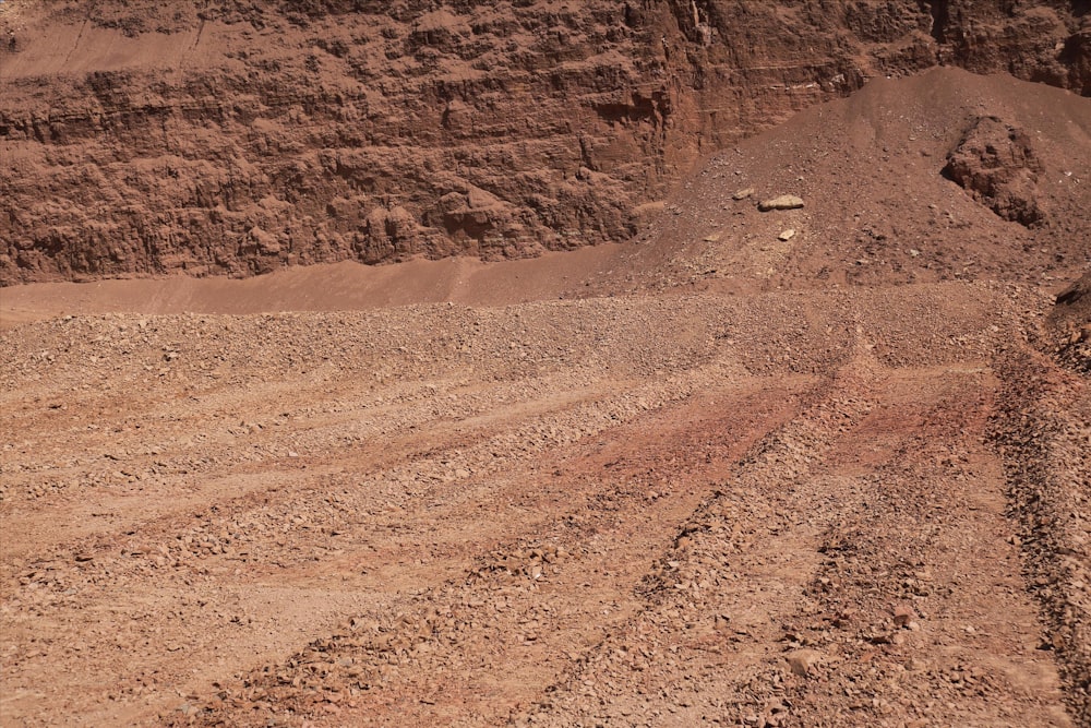 a dirt field with a mountain in the background