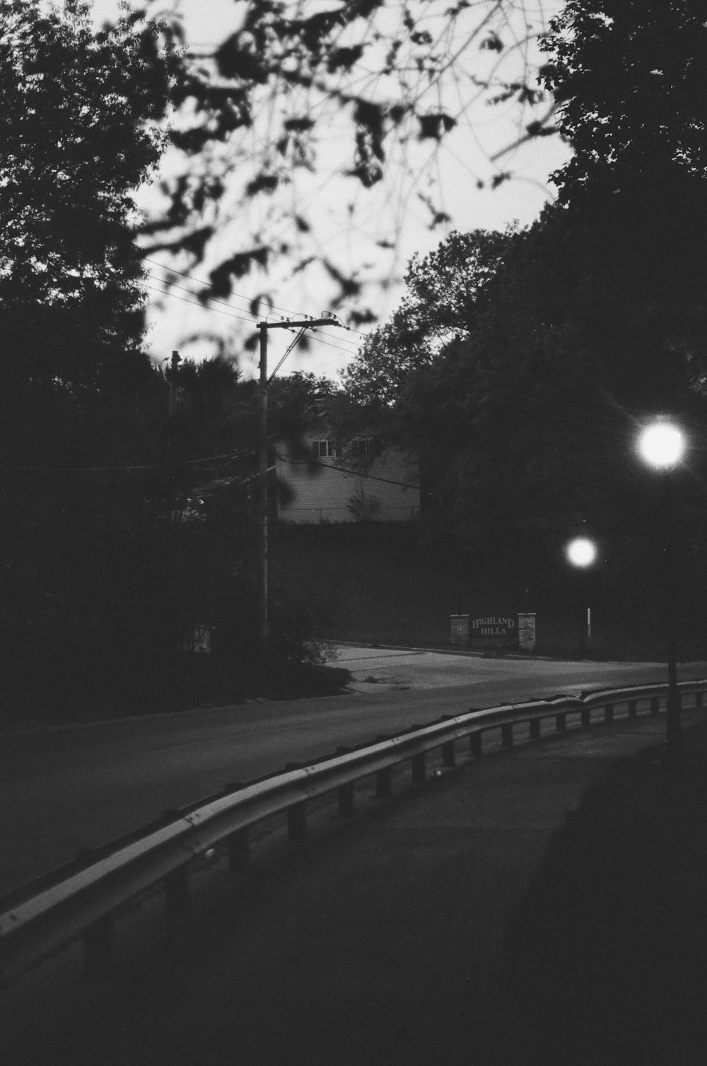 a black and white photo of a street at night