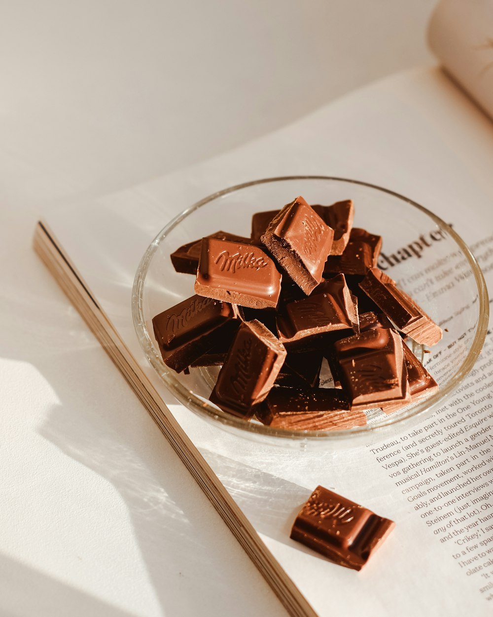 a glass plate filled with chocolate next to an open book