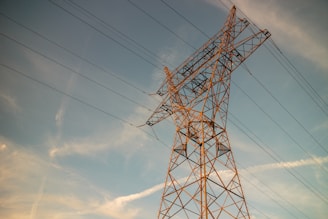 a high voltage power line against a blue sky