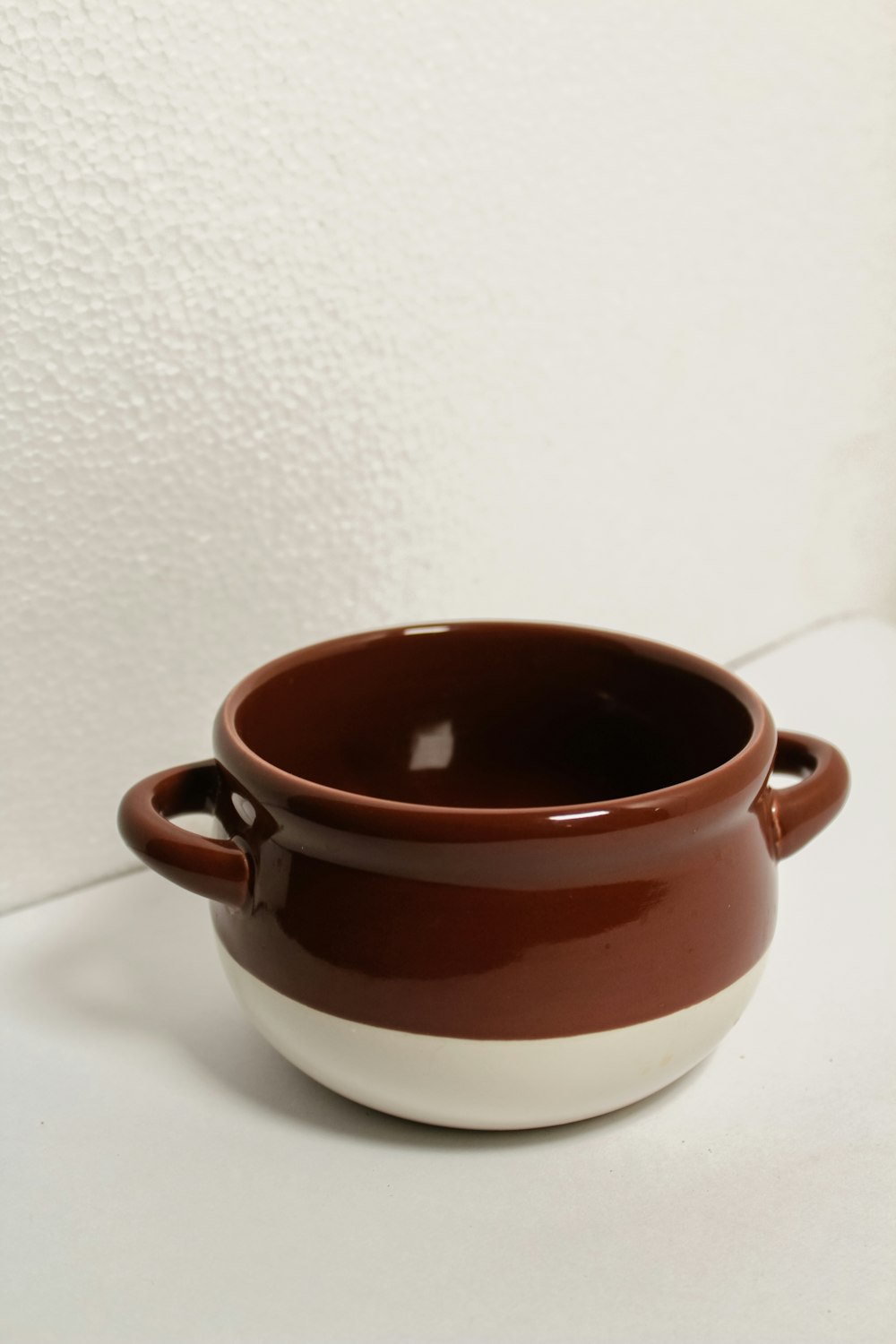 a brown and white bowl sitting on top of a table