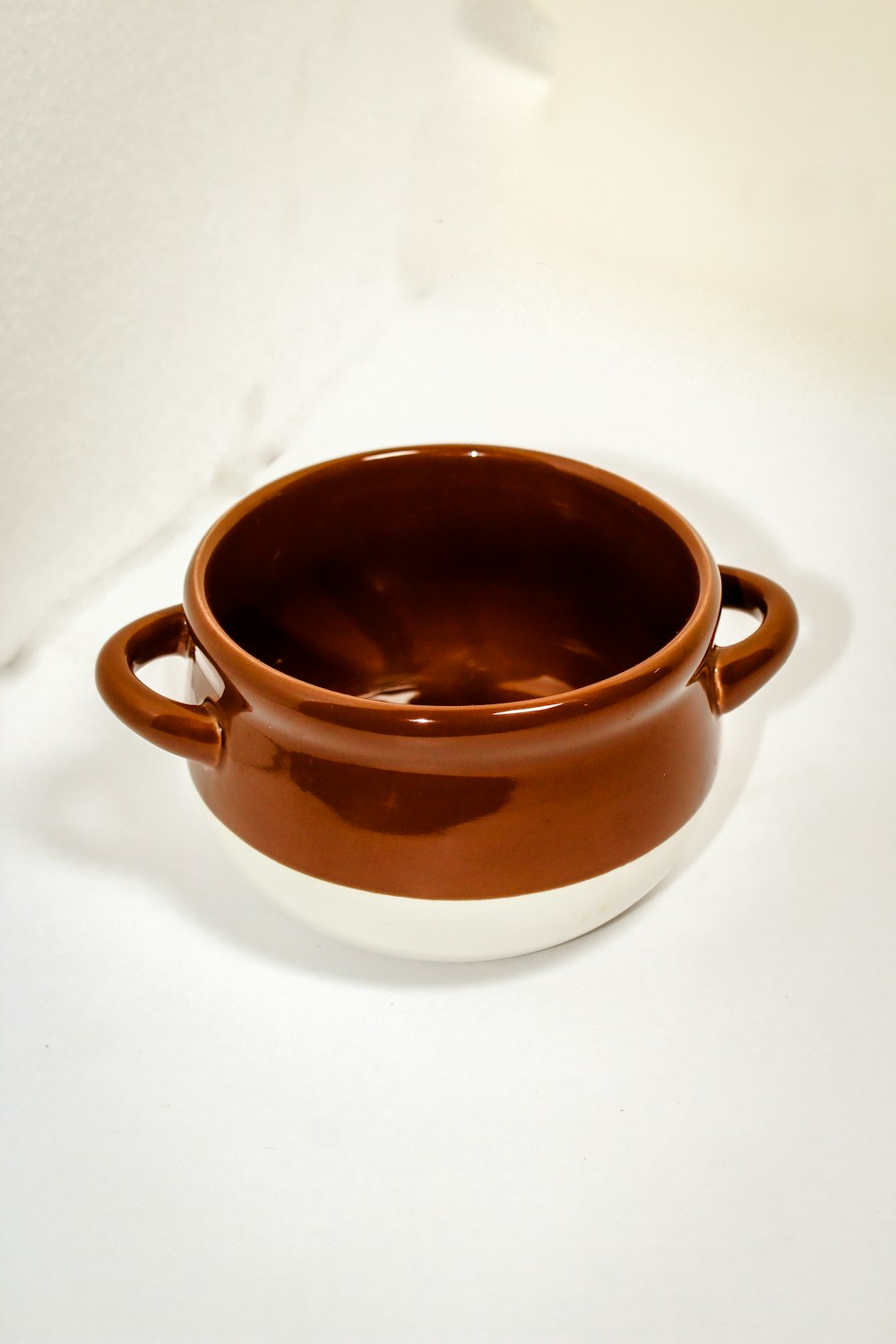 a brown and white bowl sitting on top of a table