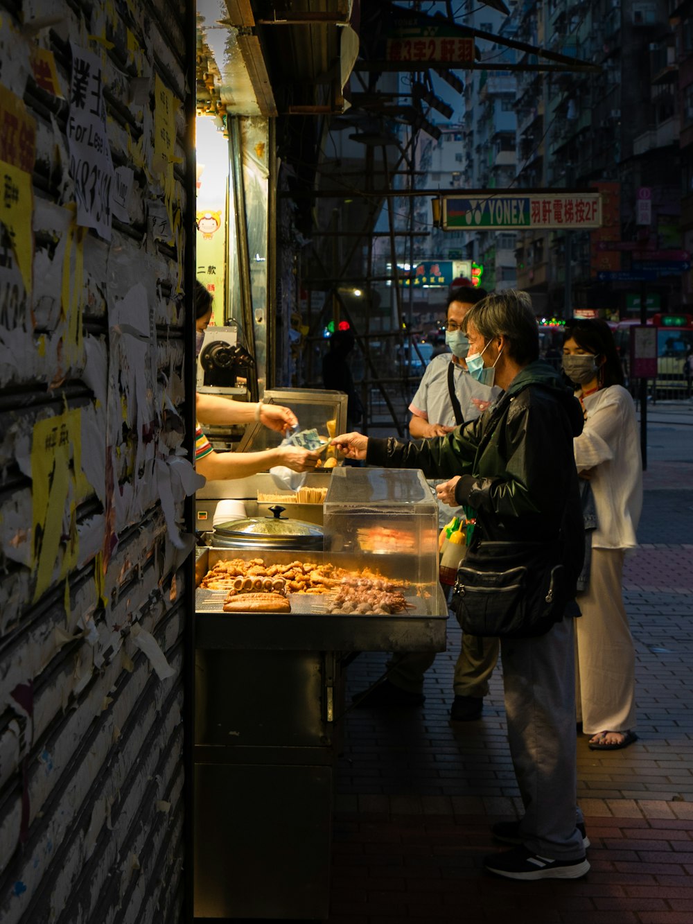 a group of people standing around a food stand