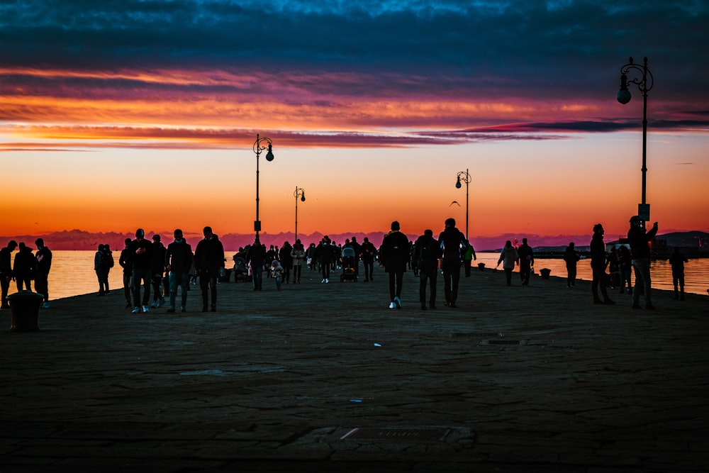 a group of people standing on top of a pier