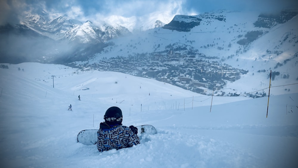 a person sitting in the snow on a snowboard
