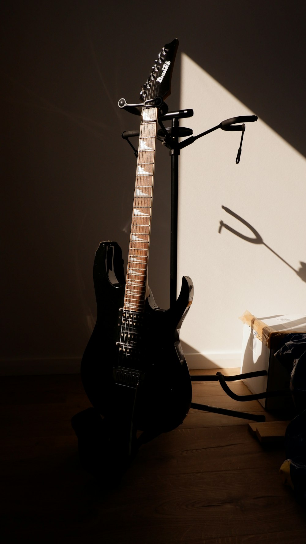 Una guitarra está sentada al lado de un soporte de guitarra