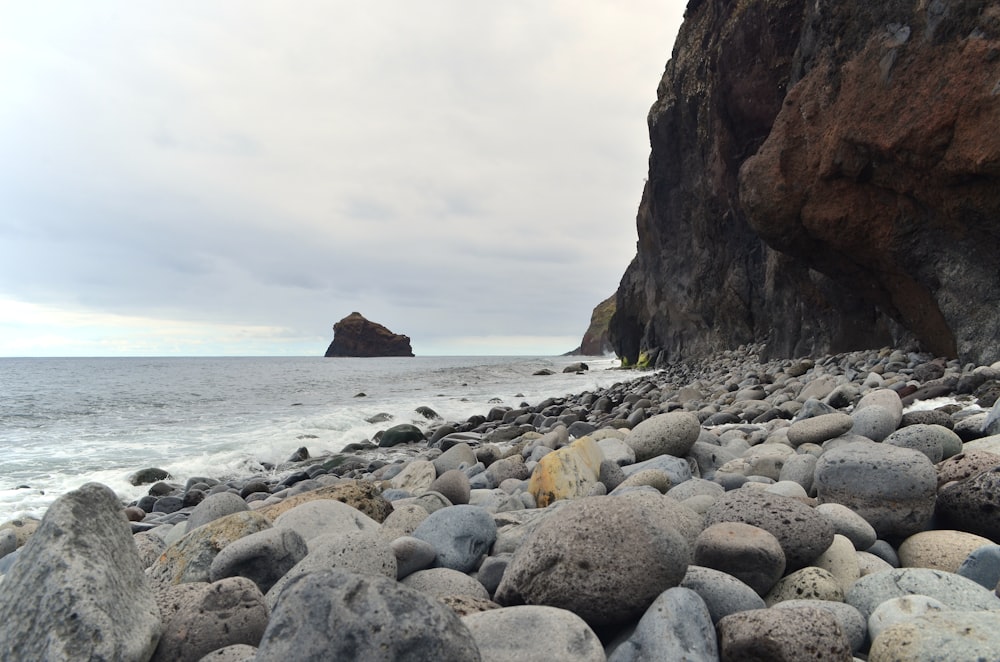 a rocky beach next to a large cliff