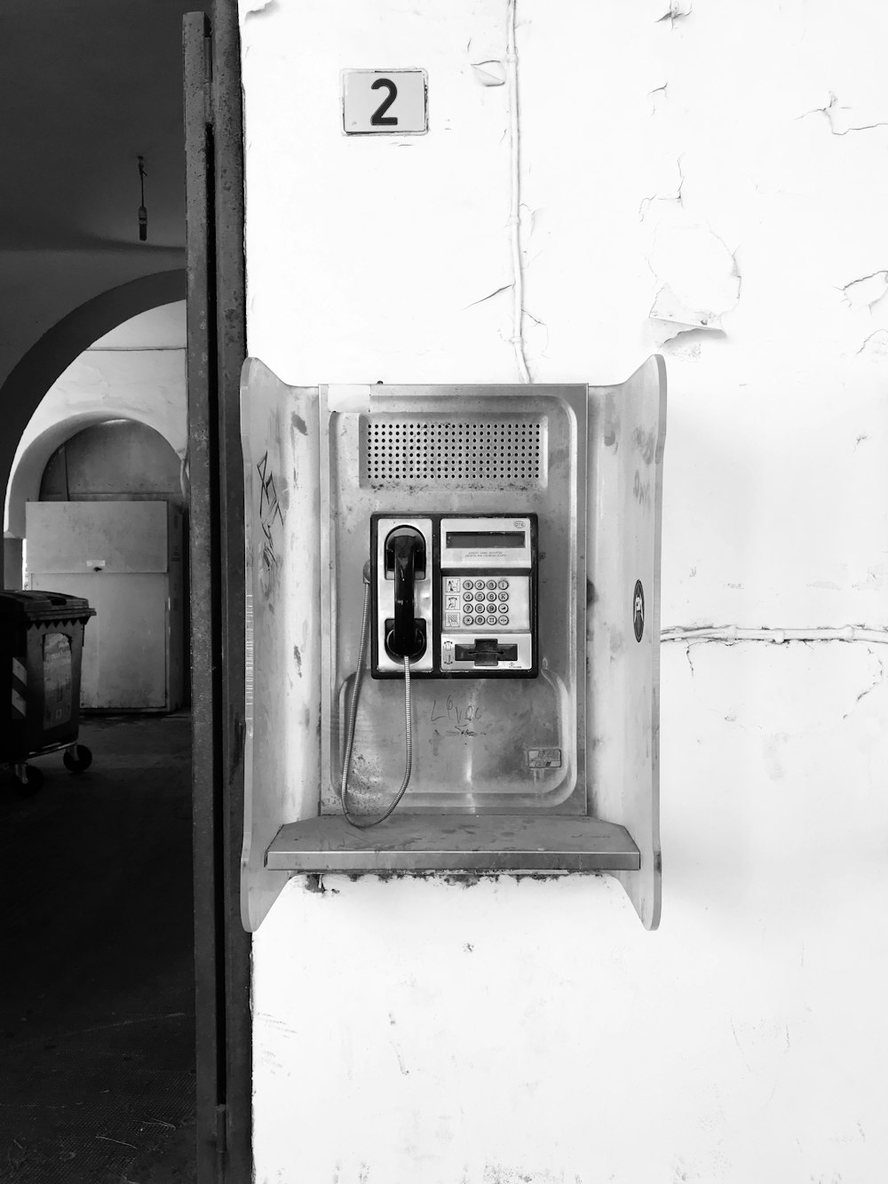 an old phone is hanging on a wall